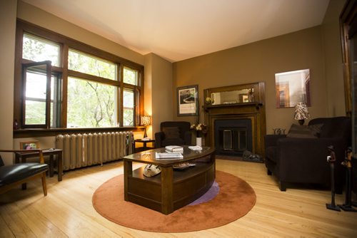 The living room of this Riverview home features a wood-burning fireplace with exquisite detailing in Winnipeg on Tuesday, July 28, 2015.  Mikaela MacKenzie / Winnipeg Free Press
