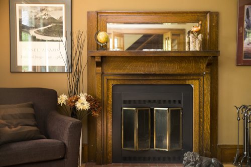 The living room of this Riverview home features a wood-burning fireplace with exquisite detailing in Winnipeg on Tuesday, July 28, 2015.  Mikaela MacKenzie / Winnipeg Free Press