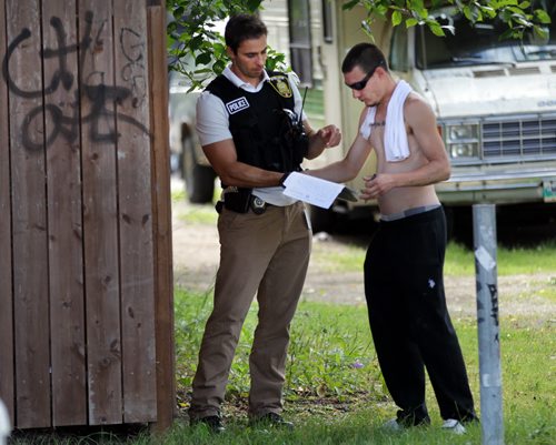 A city detective takes a statement from a witness near Taft Cresc at Nassau Tuesday afternoon after a shooting sent one man to hospital. See  story. July 28, 2015 - (Phil Hossack / Winnipeg Free Press)