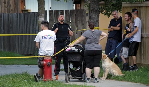 A city Police Officer guards the end of a lane behind 743 Nassaue Street South off Taft Cresc Tuesday afternoon after a shooting sent one man to hospital. See  story. July 28, 2015 - (Phil Hossack / Winnipeg Free Press)