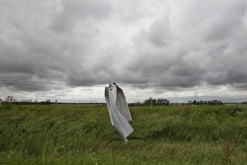 A piece of metal siding hangs from downed power lines along Hwy 256 close to Tilston, MB.  150728 July 28, 2015 MIKE DEAL / WINNIPEG FREE PRESS