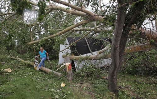 Tammy Van Beselaere removes Christmas decorations from the destroyed shed on her fathers, Fred Raynor, property that was damaged by the tornado Monday night close to Tilston, MB.  150728 July 28, 2015 MIKE DEAL / WINNIPEG FREE PRESS