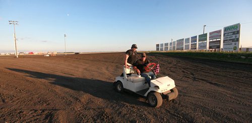 Pit crew make the trek from the trailer to the track checking conditions in a golf cart at the Red River Speedway Monday night races. See  story. July 27, 2015 - (Phil Hossack / Winnipeg Free Press)