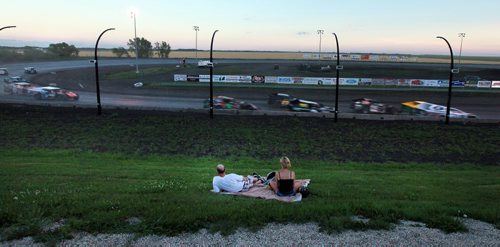 A couple on a blanket bask in the roar and dust of the Monday night races. See  story. July 27, 2015 - (Phil Hossack / Winnipeg Free Press)