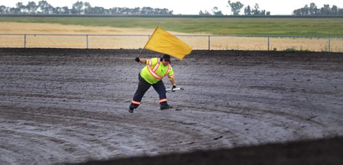 A track official under a yellow caution flag retreives a drive shaft that fell out of a race car during a race at Red River Speedway's Monday night races. See  story. July 27, 2015 - (Phil Hossack / Winnipeg Free Press)