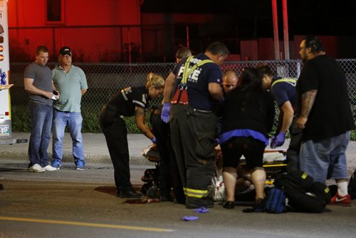 July 28, 2015 - 150728  -  The driver (L) and his passenger look on as a pedestrian hit by an east bound car is attended to on Selkirk Avenue Tuesday, July 28, 2015. John Woods / Winnipeg Free Press