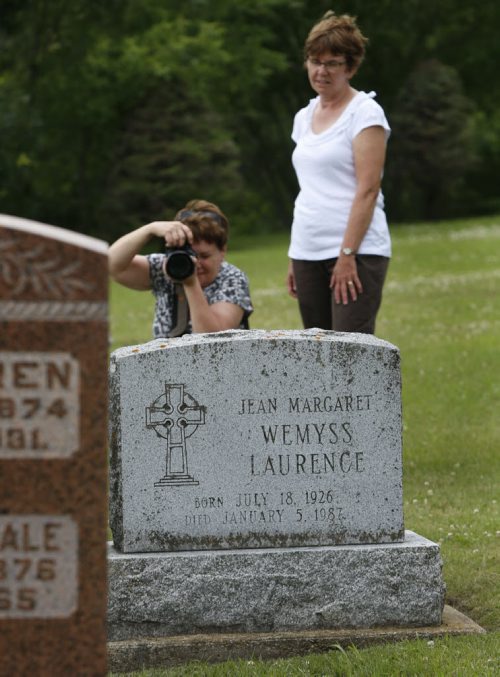 Bev Denesik takes a photograph of the grave of Margaret Laurence in the Riverside Cemetery in Neepawa Tuesday. Bev Denesik and Iona Baraniuk travelled from Saskatchewan to see the grave and the "Stone Angel" in the cemetary.   Bill Redekop story. Wayne Glowacki / Winnipeg Free Press July 28 2015