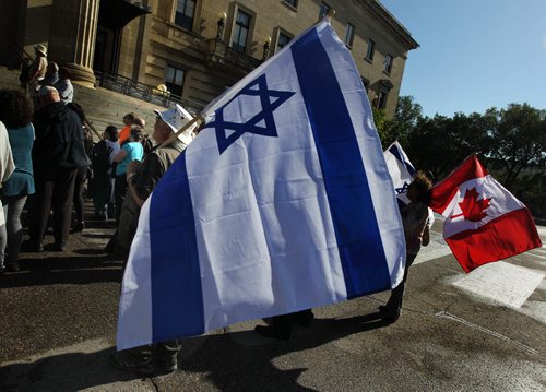 A protestors wave flags in support of the  sign of support for the Winnipeg Friends of Isreal at a rally against the US Deal with Iran. See story / Release. July 30, 2015 - (Phil Hossack / Winnipeg Free Press)