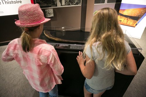 Katie Goldie (left), visiting from California, and her cousin Rosemary Bowles stop to inspect Canada's oldest known hockey stick on display at the Manitoba Museum. The stick, on loan from the Canadian Museum of History, originates from Cape Breton in the 1830s. It is shaped in the Mi'kmaq style from sugar maple wood. July 30, 2015 - MELISSA TAIT / WINNIPEG FREE PRESS