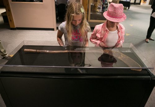 Katie Goldie (left), visiting from California, and her cousin Rosemary Bowles stop to inspect Canada's oldest known hockey stick on display at the Manitoba Museum. The stick, on loan from the Canadian Museum of History, originates from Cape Breton in the 1830s. It is shaped in the Mi'kmaq style from sugar maple wood. July 30, 2015 - MELISSA TAIT / WINNIPEG FREE PRESS