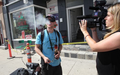 Steven Stairs a Canadian cannabis advocate lights up for the television cameras in front of the store that was selling marijuana illegally until the couple that runs it were arrested Tuesday afternoon.  150804 August 04, 2015 MIKE DEAL / WINNIPEG FREE PRESS