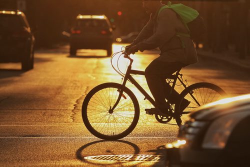 A cyclist crosses Broadway at Osborne in the early morning light Wednesday. 150805 August 05, 2015 MIKE DEAL / WINNIPEG FREE PRESS