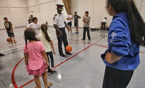 Police Chief Devon Clunis plays basketball after the daily media briefing which was held at the Turtle Island Neighbourhood Centre so that the police could highlight the good work that programs like Drop Zone, a summer youth sports drop-in, are vital to help children gain confidence and learn "leadership, integrity and good citizenship." 150806 August 06, 2015 MIKE DEAL / WINNIPEG FREE PRESS