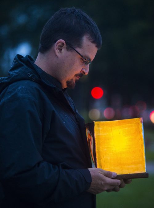 David Nickarz looks down at his lantern after an event commemorating the atomic bomb attacks on Hiroshima and Nagasaki in Memorial Park in Winnipeg on Thursday, Aug. 6, 2015.  Mikaela MacKenzie / Winnipeg Free Press