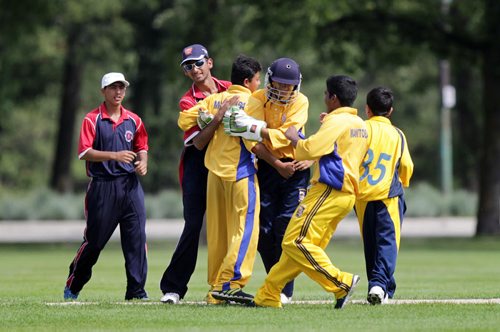 Combined Manitoba (in yellow) / Quebec (in Blue) team members celebrate around wicket keeper Shiv Moaghil (in helmet) Friday afternoon in the final day of the Cricket Canada U-16 Championships.  See Tim Campbell's story. August 7, 2015 - (Phil Hossack / Winnipeg Free Press)