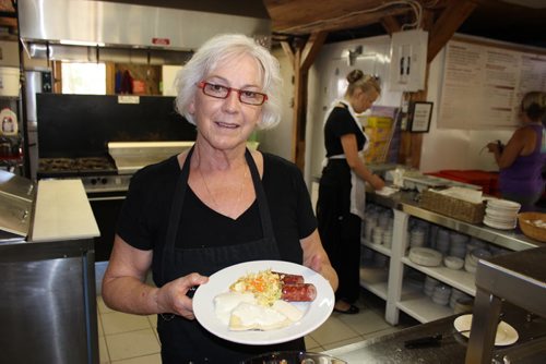 Dora Penner of the Livery Barn Restaurant holds up a traditional Mennonite lunch of farmer sausage, vereniki, and cole slaw. BILL REDEKOP/WINNIPEG FREE PRESS July 31,  2015