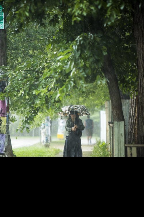 Maria Kucparic walks down Westminister Avenue during a downpour in Winnipeg on Friday, Aug. 7, 2015.    Mikaela MacKenzie / Winnipeg Free Press