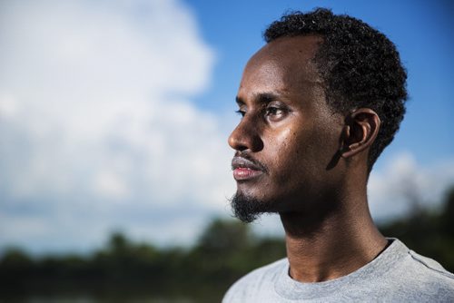 Yahya Samatar, refugee claimant from Somalia who swam across the Red River to get to Canada, stands by the river in Winnipeg on Friday, Aug. 7, 2015.    Mikaela MacKenzie / Winnipeg Free Press
