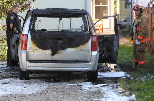 A burnt out van sits behind a residence in the 300 block of Anderson Ave. Sunday morning. The fire also damaged the power lines, though only the one house seems to be affected.  150809 August 09, 2015 MIKE DEAL / WINNIPEG FREE PRESS