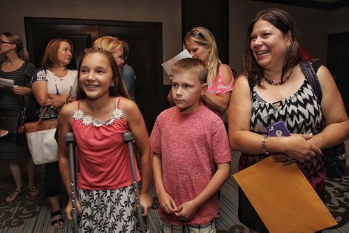 Siblings Halle, 12 (left), and Hayden Fortier, 10 (centre), with mom Marge (right) in the line that weaves back and forth inside the conference level for the casting call at Fairmont Sunday for a movie starring Dennis Quaid, Peggy Lipton and Britt Robertson. 150809 August 09, 2015 MIKE DEAL / WINNIPEG FREE PRESS