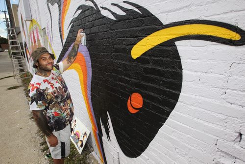 Mural artist Cash Akoza works on his latest installation on the side of Telesky Taxidermist at 545 Arlington Street. Called "Prairie Spirits," the large mural pays homage to the animal spirits that pass through the taxidermist. Akoza has created around twenty murals, both indoor and outdoor and is already planning his next work of art.  150810 August 10, 2015 MIKE DEAL / WINNIPEG FREE PRESS