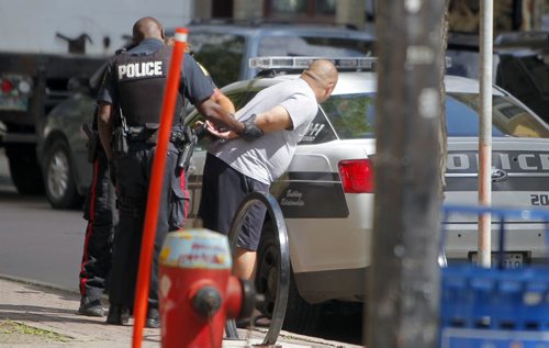 Police appear to do a sobriety test on a man on Albert Street near Old Market Square. They cuffed him and took him away. BORIS MINKEVICH / WINNIPEG FREE PRESS PHOTO August 11, 2015