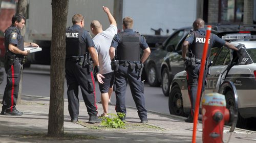 Police appear to do a sobriety test on a man on Albert Street near Old Market Square. They cuffed him and took him away. BORIS MINKEVICH / WINNIPEG FREE PRESS PHOTO August 11, 2015