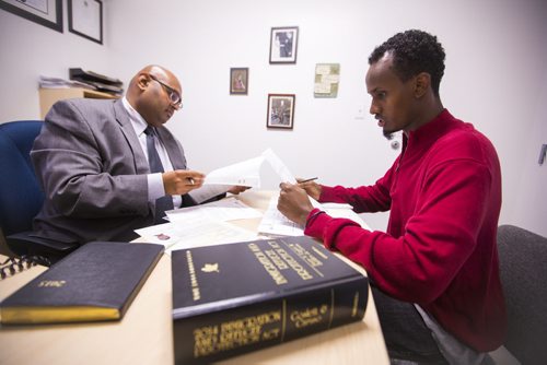 Yahya Samatar talks to his lawyer, Bashir Khan, at the Welcome Place in Winnipeg on Wednesday, Aug. 12, 2015.  Samatar has spent much of the last few days filling out many complex documents with help from staff.   Mikaela MacKenzie / Winnipeg Free Press