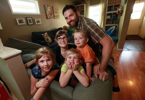 Dave and Jani Colvinson pose with their three kids L-R Corrina (8), Annika (4) and Walter (2) in their West End home. The entire family is going to camp next week courtesy of the Sunshine fund. See Story.  August 12, 2015 - (Phil Hossack / Winnipeg Free Press)