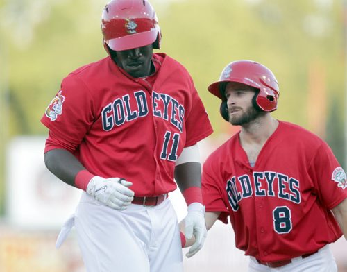 Goldeye center fielder # 11 Reggie Abercrombie gets a pat on the behind from #8 Adam Heisler after the pair scored runs after his home run to open the scoring Wednesday at Shaw Park against Souix Falls Canaries. See story.    August 12, 2015 - (Phil Hossack / Winnipeg Free Press)