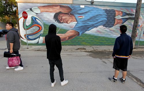 The West End's BIZ mural is observed by some local kids on the the side of X-Cues on Seargent. BORIS MINKEVICH / WINNIPEG FREE PRESS PHOTO August 13, 2015