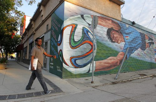 The West End's BIZ mural on the the side of X-Cues on Seargent. An unnamed man walk by. BORIS MINKEVICH / WINNIPEG FREE PRESS PHOTO August 13, 2015