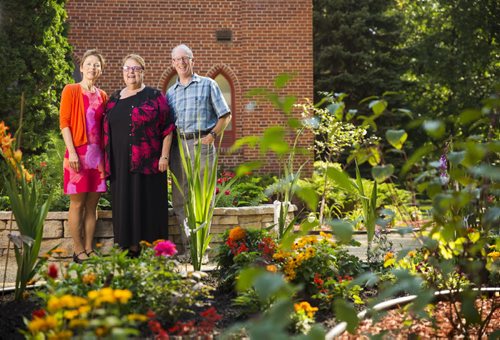 Arlene Baschak (left), Rev. Janet Walker, and Wayne Arklie stand in the memory garden (a garden for the burial of cremated remains for anyone in the community) at Churchill Park United Church in Winnipeg on Thursday, Aug. 13, 2015.  Mikaela MacKenzie / Winnipeg Free Press