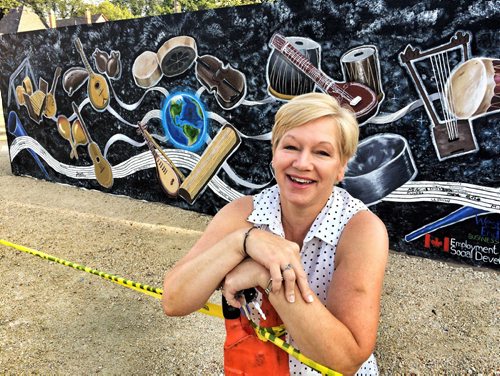 West End Biz exec director Gloria Cardwell-Hoeppner poses in front of the mural the kids drew where the building on Sargent used to be. Press conference is at 10. BORIS MINKEVICH / WINNIPEG FREE PRESS PHOTO August 13, 2015