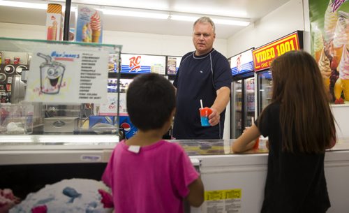 Ken Taylor manages Video 1001, one of the last video stores in Winnipeg, on Mountain Avenue on Friday, Aug. 14, 2015.  The store also has ice cream, slushies, food, lotto tickets, laundry, and more. Mikaela MacKenzie / Winnipeg Free Press
