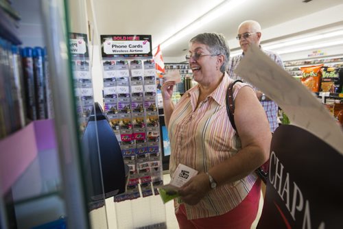 Donna Templeton checks her lottery tickets at Video 1001, just like she does every week, at the store on Mountain Avenue on Friday, Aug. 14, 2015.  The store also has ice cream, slushies, food, lotto tickets, laundry, and more. Mikaela MacKenzie / Winnipeg Free Press