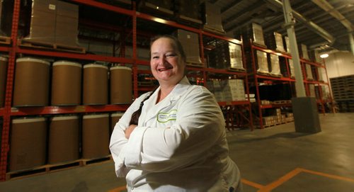 Kelly Beaulieu poses in a warehouse with barrels and pallets packed with vegetable puree made from what would have been "waste" or unusable (blemished) veggies at the farm. Her firm "Prairie Garden takes the mis-shaped produce and produces vegetable purees. See Bruce Owen's story. August 13, 2015 - (Phil Hossack / Winnipeg Free Press)