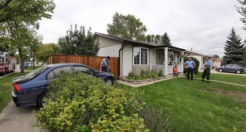 A car sits in the yard of a house at 876 Louelda Street Sunday as the homeowner emergency personnel look on. No injuries were reported.  150816 August 16, 2015 MIKE DEAL / WINNIPEG FREE PRESS