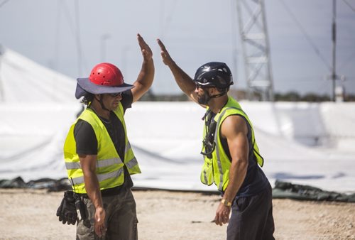 Workers high-five each other as they set up the Cavalia big top in Winnipeg on Tuesday, Aug. 18, 2015.   Mikaela MacKenzie / Winnipeg Free Press