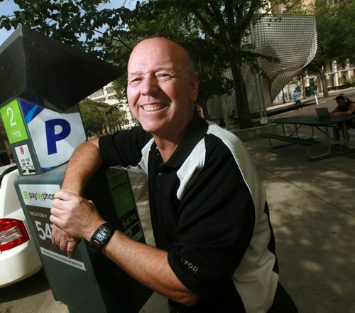 Brian Timmerman, ex-dir Exchange District BIZ poses beside a parking pay station Tuesday.  Where you park downtown can make a difference to your wallet. The Winnipeg Parking Authority has differentiated rates for on-street parking -- $1 per hour for most locations throughout the downtown and the Exchange District; $2 per hour for spots close to city  hall, the theatre district, Law Courts complex, and the MTS Centre. Its a deliberate strategy targeting the most popular locations where motorists were parking up to eight hours a day. SANTIN w/map showing the $2 per hour street; and a fact box. OURS ALONE August 18, 2015 - (Phil Hossack / Winnipeg Free Press)