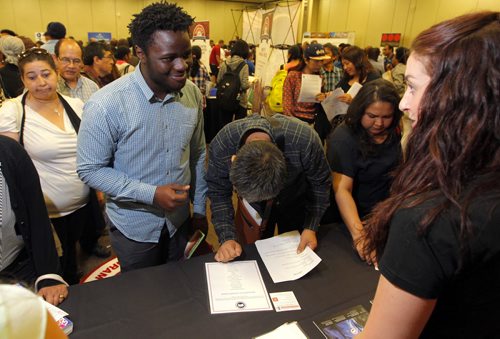 Immigrant Job Fair. 29 employers have booths, 1,000 immigrants expected to attend. (Ashley story) RBC Convention Centre. left, Timmy Jude talks to a representative from Canada Goose company BORIS MINKEVICH / WINNIPEG FREE PRESS PHOTO August 19, 2015