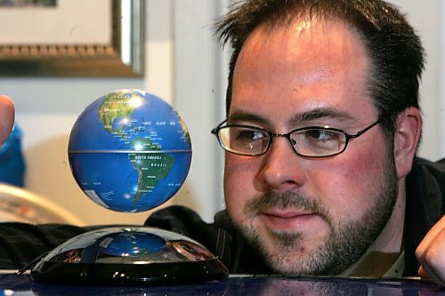 BORIS MINKEVICH / WINNIPEG FREE PRESS  071210 Gizmos Galaxy owner Kevin Mlodzinski poses with some floating globes in his St. Vital Mall store.