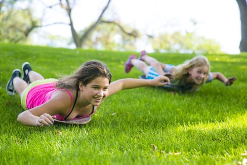 Hailey (left) and her friend Holly roll down a grassy hill on their longboards in Saint John's Park in Winnipeg on Thursday, Aug. 20, 2015.   Mikaela MacKenzie / Winnipeg Free Press