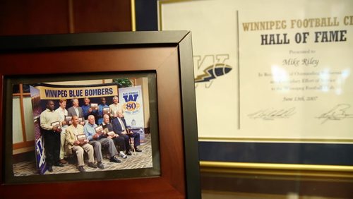 Photos on the shelf of Riley's office in Nebraska of his induction into the Winnipeg Blue Bombers Hall of Fame in 2007. August 20, 2015 - Melissa Tait / Winnipeg Free Press