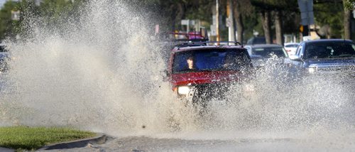 A motorist ploughs through the water flooded north bound lanes on Main St. in the Leila Ave. area after a water main break Friday morning.    Wayne Glowacki / Winnipeg Free Press August 21 2015
