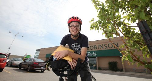 Ryan Schellenberg is a McNally Robinson employee who will courier a book to a customer as part of a new service offered by the book store.   See story.  Aug 21, 2015 Ruth Bonneville / Winnipeg Free Press