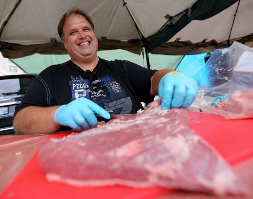 Gary Rose from Smokin' Squealers BBQ trims the fat off a beef brisket, that will then take around 10 hours to cook, at the Winnipeg BBQ and Blues festival, Friday, August 21, 2015. (TREVOR HAGAN/WINNIPEG FREE PRESS)