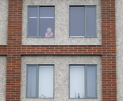 A woman watches Stephen Dubienski defeating Cole Lacap in the Manitoba Open, from her apartment overlooking the court, at the Kildonan Tennis Club, Friday, August 21, 2015. (TREVOR HAGAN/WINNIPEG FREE PRESS)