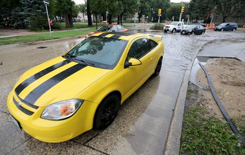 A stalled car sits on River Avenue near Kirkness Avenue after travelling through a deep puddle, Saturday, August 22, 2015. (TREVOR HAGAN/WINNIPEG FREE PRESS)