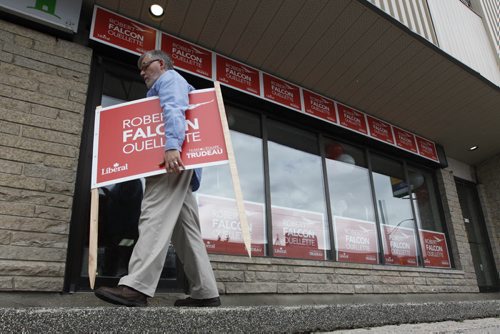 August 23, 2015 - 150303  -  A supporter leaves with a lawn sign after Robert-Falcon Ouellette officially kicked-off of his campaign in his campaign office Sunday, August 23, 2015. John Woods / Winnipeg Free Press